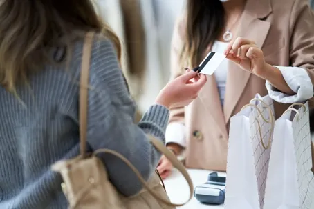 An image of two girls giving a card to another girl.